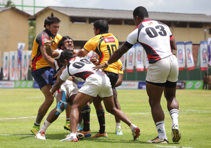 Central Kings player Chula Susantha grimaces as he is tackled by Northern Gladiators Rohitha Rajapaksa and Nigel Ratwatte on the opening day of the domestic Carlton Sevens in Kurunegala yesterday